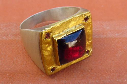 <b>משובץ T118-24</b> - טבעת חותם מרובעת מכסף עטופה בפח זהב 24K מרוקע, משובצת בגרנט